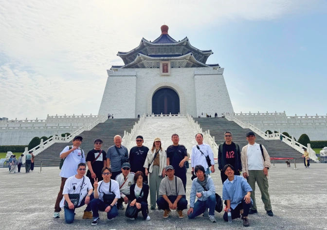 社員旅行で訪れた建物を背景にした集合写真